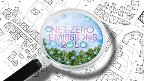 plano con una lupa sobre edificios Net Zero
