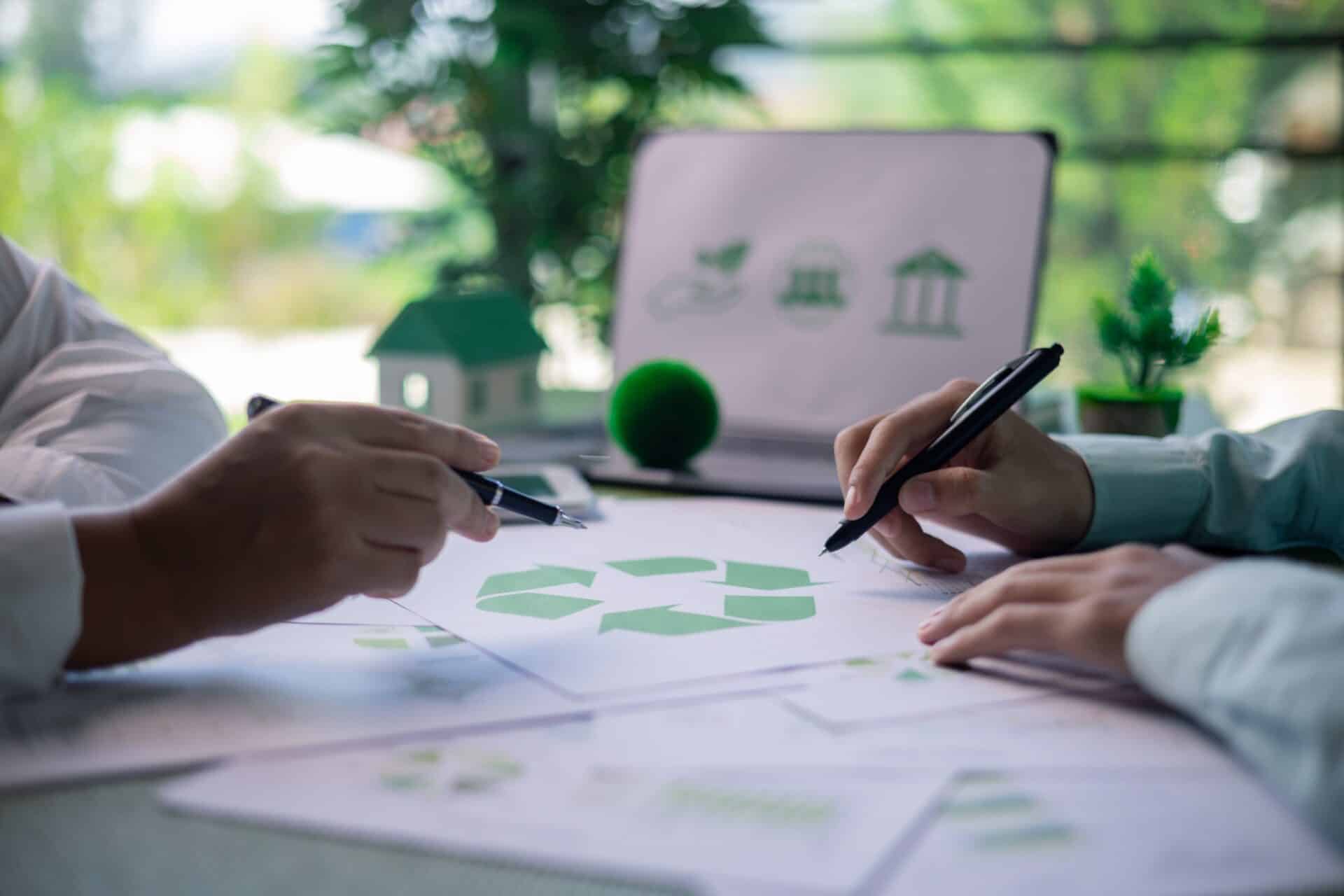 Dos personas en una mesa con planos de una construcción sostenible.