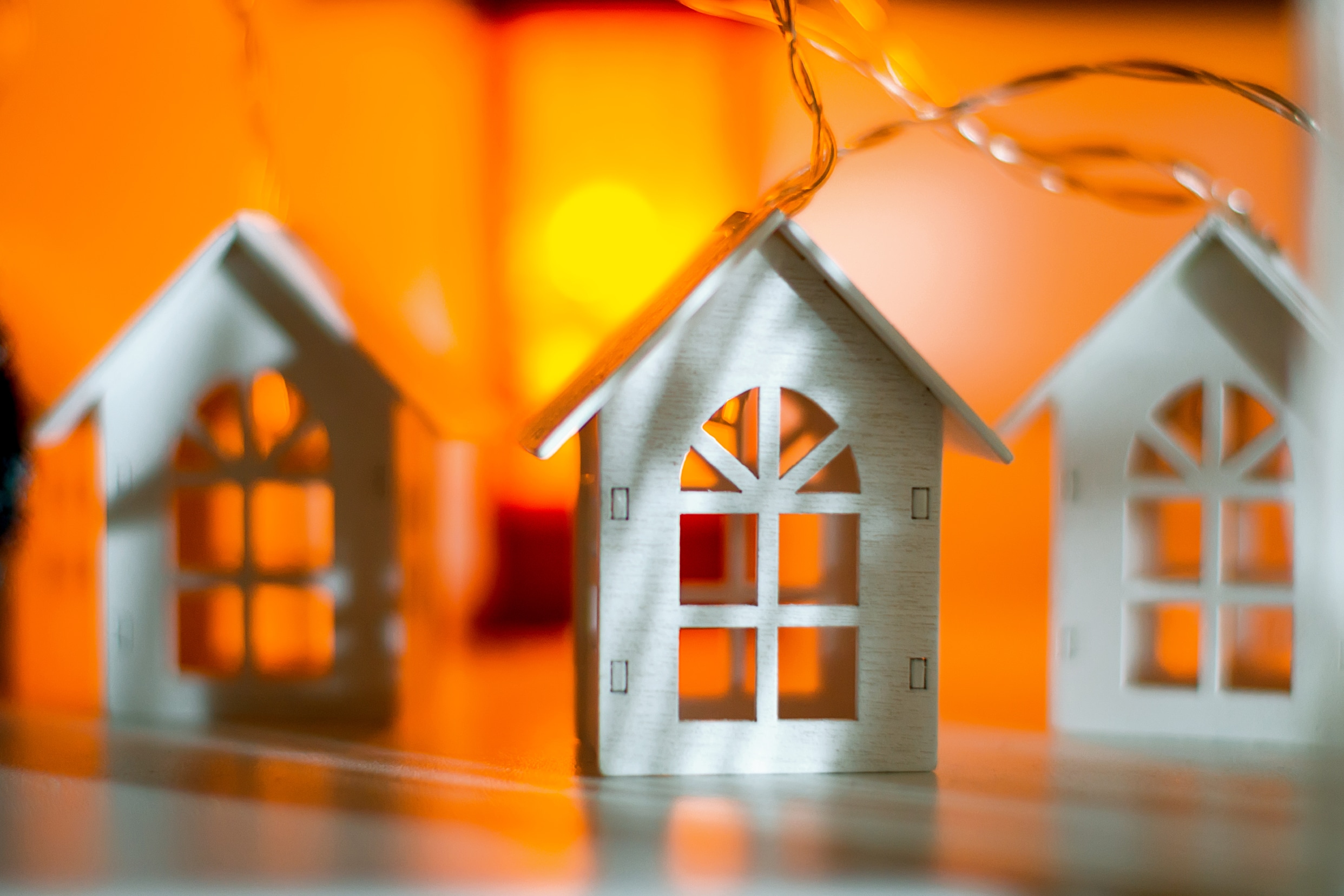 Miniatura de la fachada de una casa con el fondo iluminado de colores cálidos